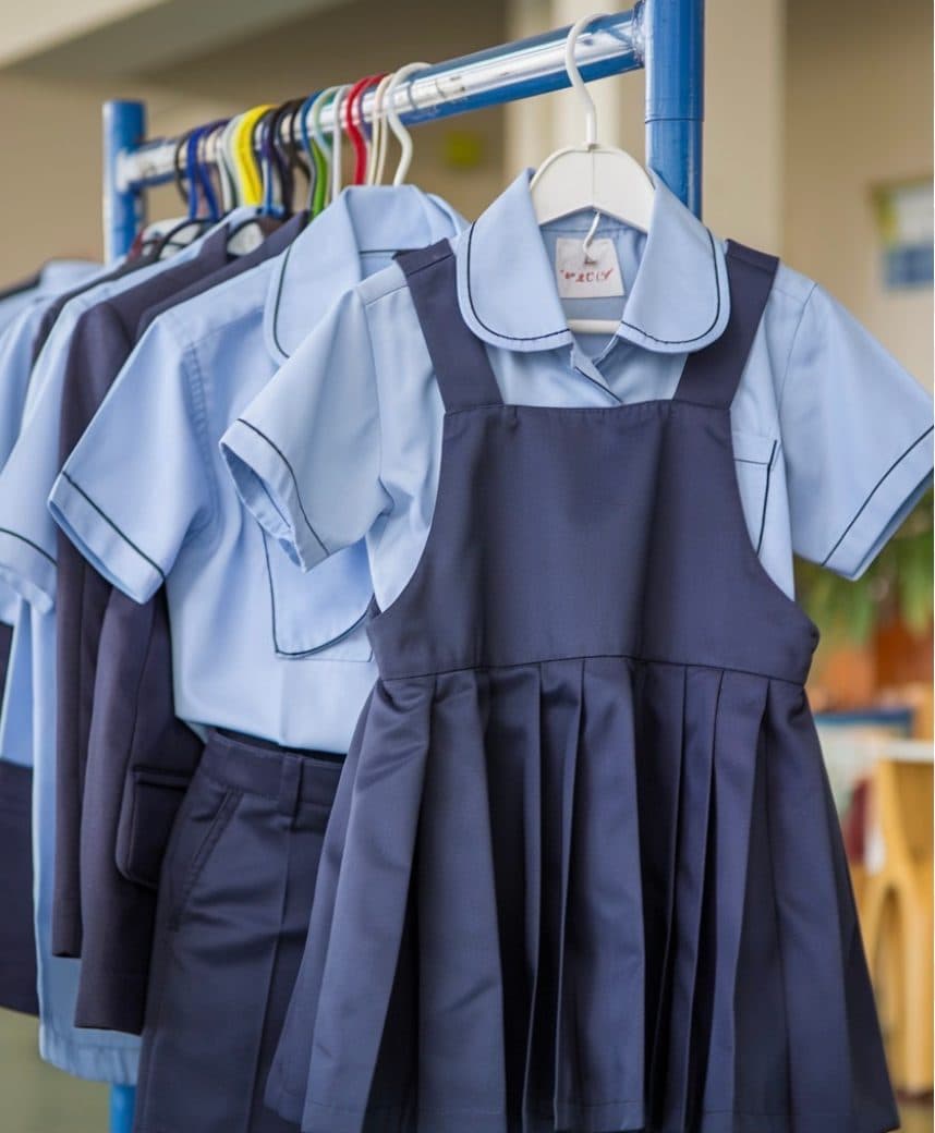 Uniformes scolaires bleus suspendus à une tringle
